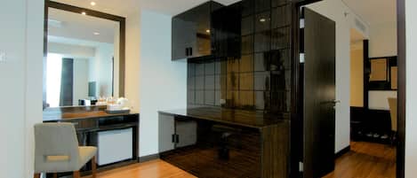 A modern kitchen with a dark wood finish, a built-in refrigerator, and a wooden dining table.
