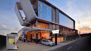 Un hotel moderno con un diseño arquitectónico único, que destaca por su fachada curva y numerosos balcones.