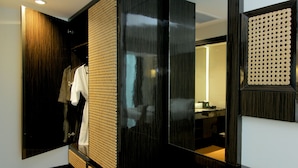 Una habitación de hotel moderna con vestidor, un espejo grande y suelo de madera.