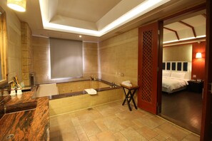 A modern bathroom with a bathtub, a sink, and a mirror. - Seasons Boutique Motel (Kaohsiung)