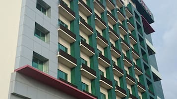 A multi-story hotel with a modern design, featuring a mix of balconies and windows.