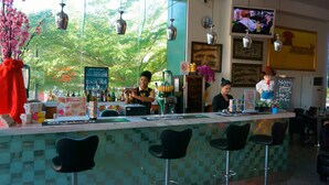 A bar with a tiled backsplash, hanging lights, and a TV mounted on the wall. - Hotel Aifa (Labuan)