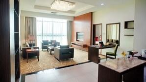 A modern hotel room with a living area, a dining area, a TV, and a large window with curtains. - Hotel Aifa (Labuan)