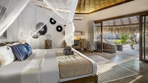 A bedroom with a canopy bed, a view of the garden, and a thatched roof ceiling. - SEED Resort (Rote Island)