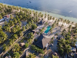 An aerial view of a resort with a swimming pool, palm trees, and a beach. - SEED Resort (Rote Island)