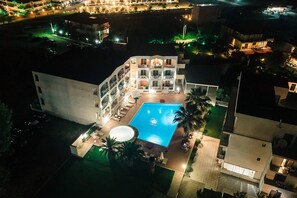 Una piscina al aire libre de temporada, sombrillas