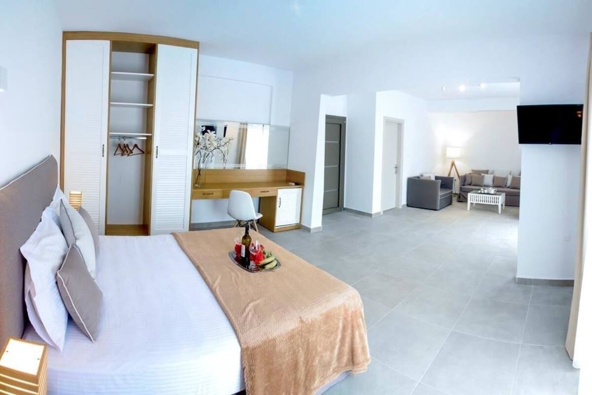 A hotel room with a bed, a desk, a TV, and a walk-in closet.
