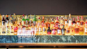 A bar with a variety of liquor bottles and glasses. - The Queens Hotel Gladstone (Gladstone)