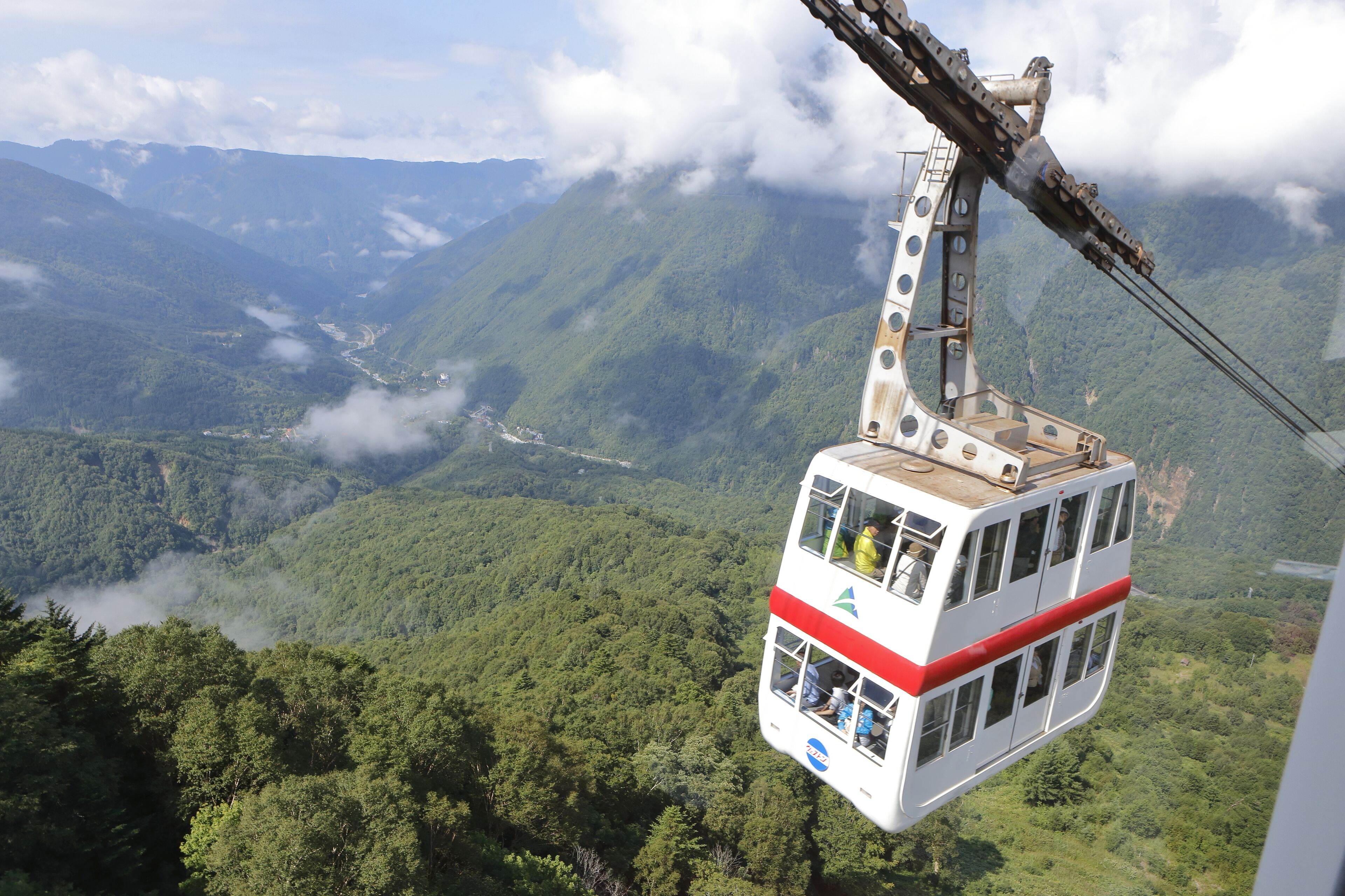 A cable car suspended over a mountainous landscape.