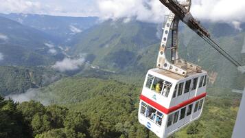 A cable car suspended over a mountainous landscape.