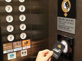 An elevator with floor indicators, a card reader, and directional signs in multiple languages.