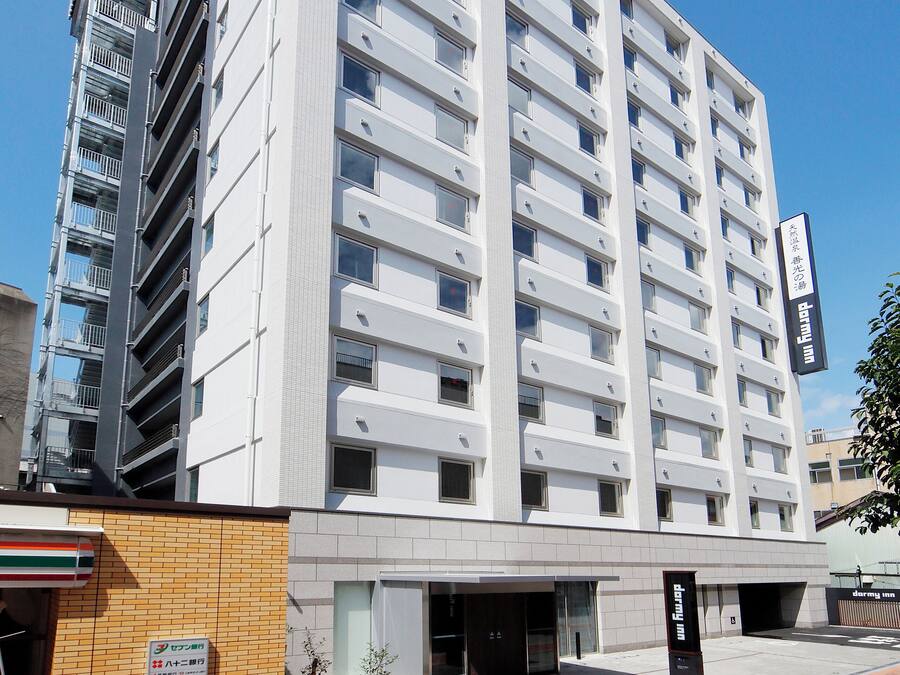 Een hotel met meerdere verdiepingen, met een modern ontwerp, een opvallende ingang en een goed zichtbaar bord.