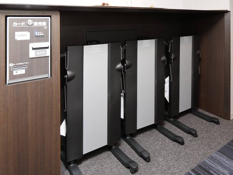 A hotel room with a wooden panel, a card reader, and a minibar.