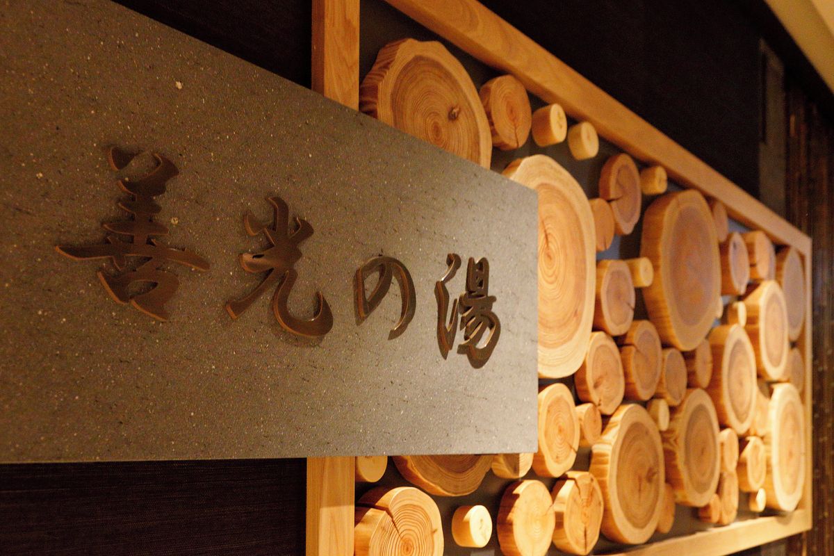 A sign with Japanese characters, surrounded by wooden logs.