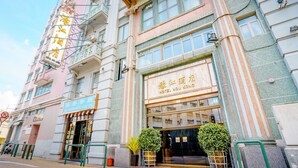 A hotel with a traditional facade, large windows, and a sign indicating it is a hotel. - Hou Kong Hotel (Macau)