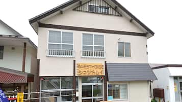 A two-story building with a sign reading "Guest House Shikotsu Kamui".