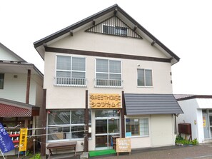 A two-story building with a sign reading "Guest House Shikotsu Kamui".