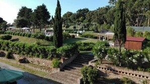 A landscaped garden with a gazebo, a wooden structure, and a brick pathway.