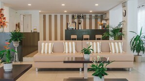Una sala de estar moderna con un conjunto de sofás, una mesa de centro y una zona de bar al fondo.