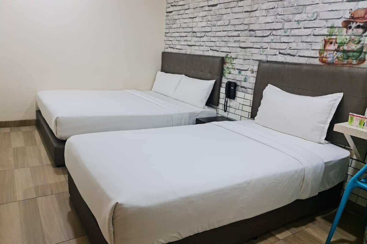 Ein Hotelzimmer mit zwei Einzelbetten, einer Wand mit Ziegelmuster, einem kleinen Tisch mit Telefon und einem blauen Stuhl.