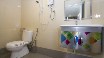 A bathroom with a toilet, a shower, and a sink with a colorful cabinet.