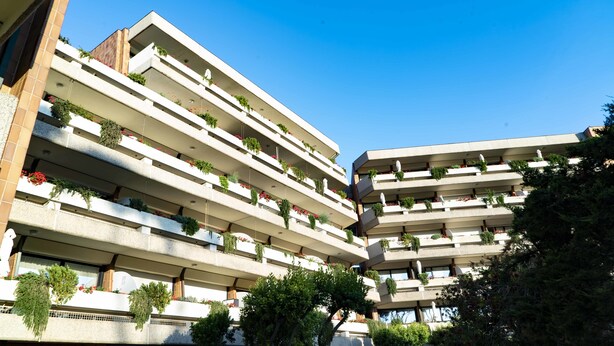 A multi-story building with balconies, each adorned with plants and flowers. - Suites Marilia Apartments (Livorno)