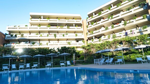 A hotel with multiple balconies, a swimming pool, and sun loungers. - Suites Marilia Apartments (Livorno)