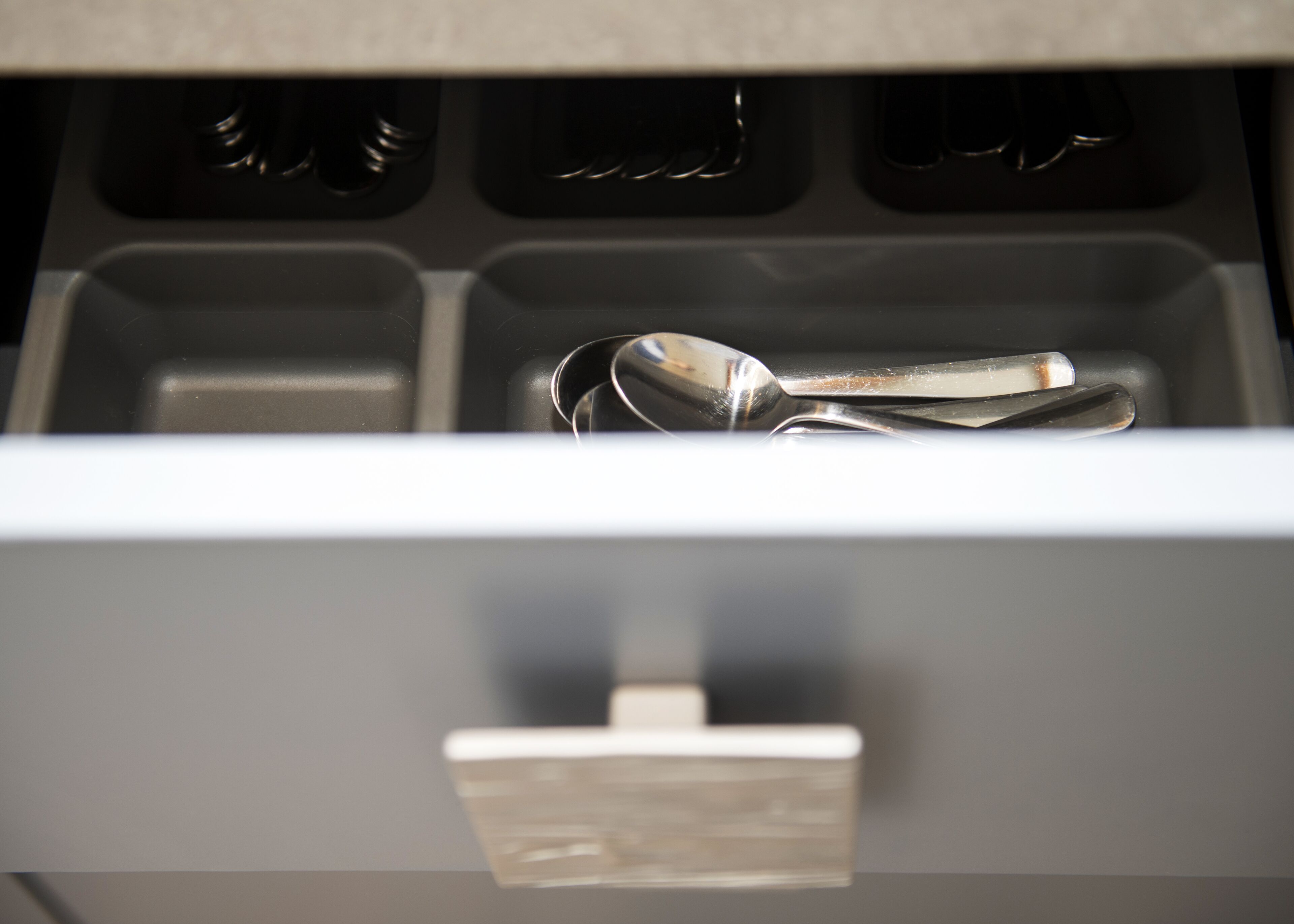 A drawer with a spoon inside.