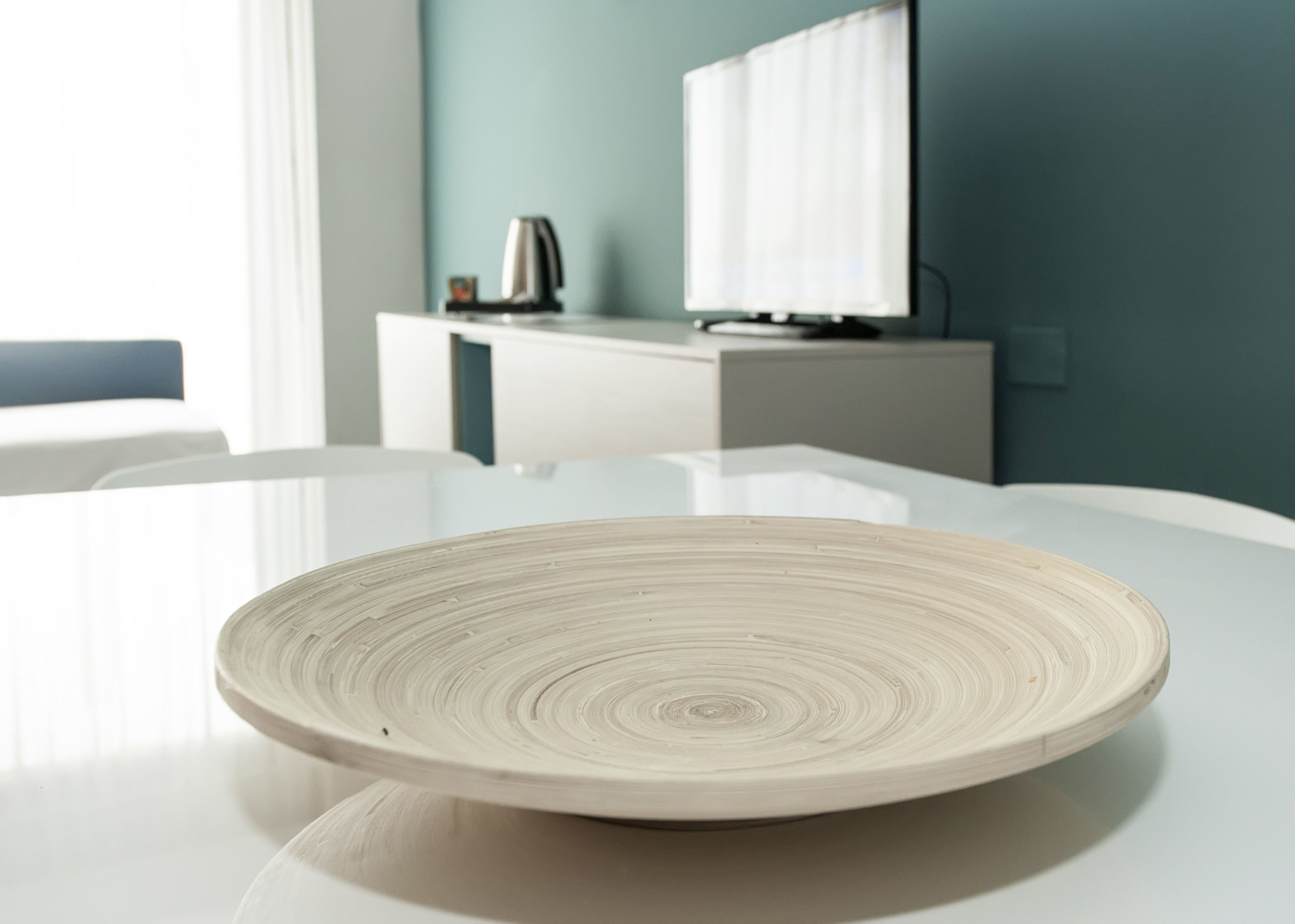 A modern dining table with a white plate in the foreground.