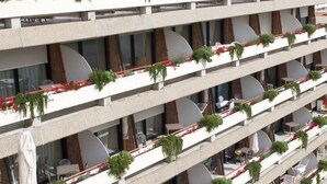 A multi-story hotel with balconies adorned with potted plants and flowers. - Suites Marilia Apartments (Livorno)