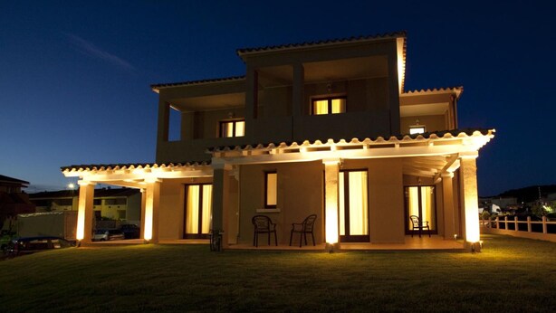 A two-story house with a covered patio area and a carport. - Xenia Hotel (Villasimius)