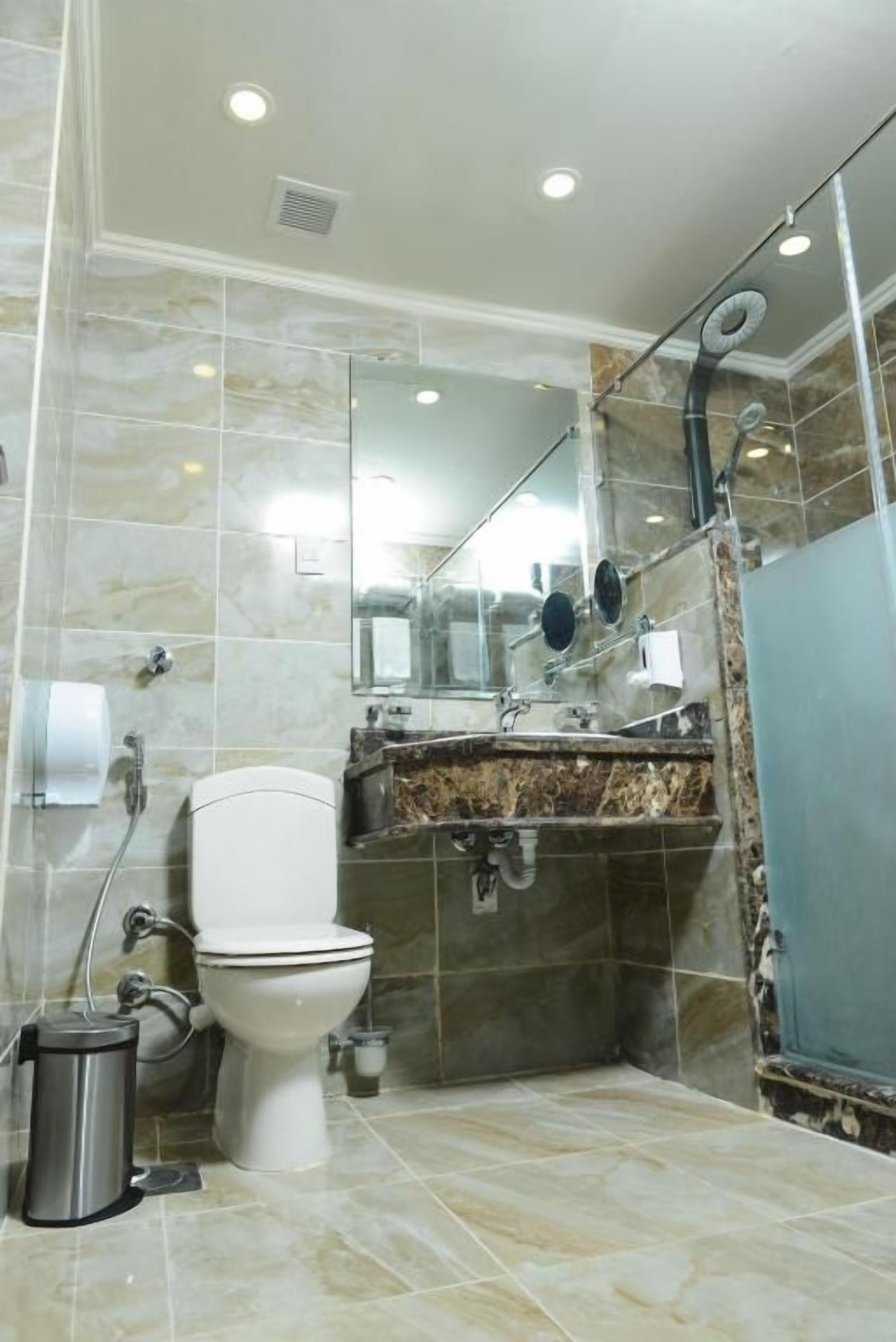 A bathroom with a toilet, sink, and shower.