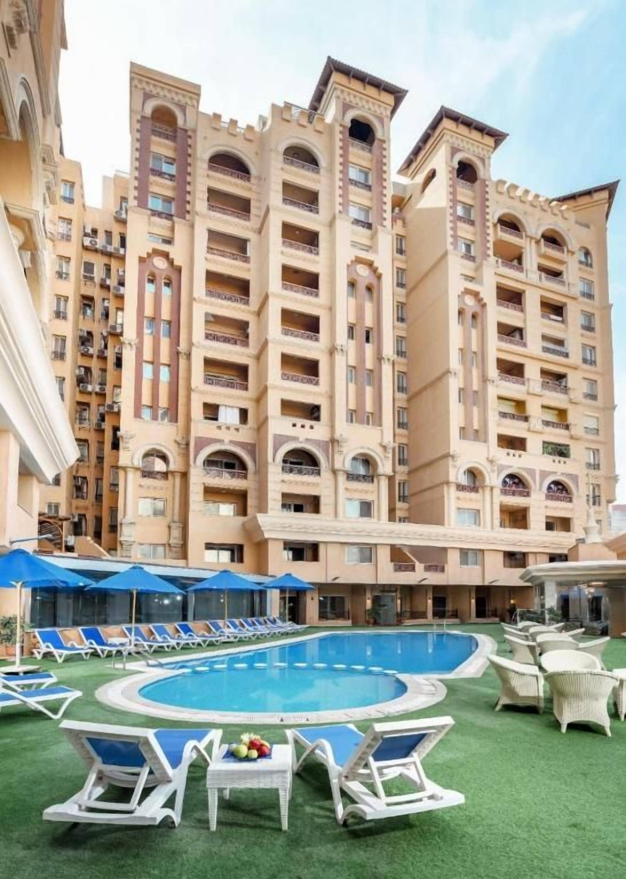 A hotel with multiple floors, a swimming pool, and outdoor seating areas.