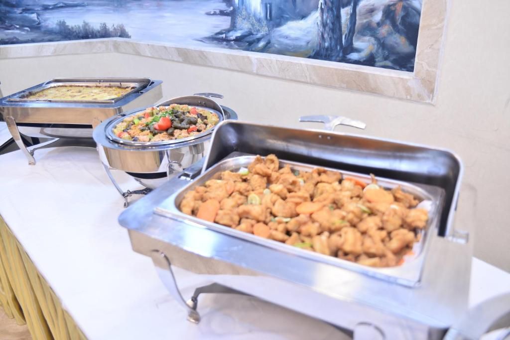 A buffet with various dishes, including what appears to be fried chicken, a casserole, and a vegetable dish.
