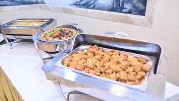 A buffet with various dishes, including what appears to be fried chicken, a casserole, and a vegetable dish.