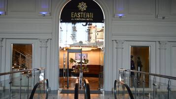 The entrance to the Eastern Al Montazah Hotel with a grand archway, a reception desk, and a glass elevator.