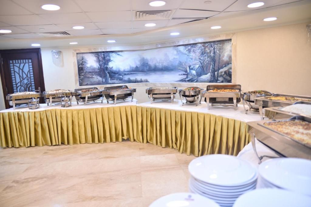 Un buffet avec plusieurs points de service et un grand tableau accroché au mur.