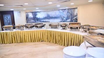 Un buffet avec plusieurs points de service et un grand tableau accroché au mur.
