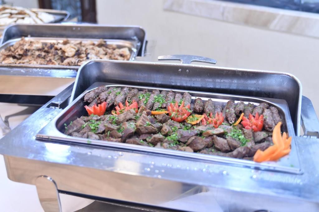 A buffet with various dishes, including meat and vegetables.