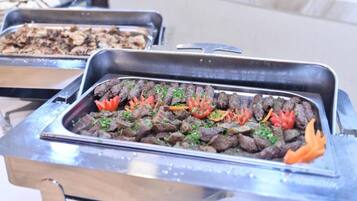 A buffet with various dishes, including meat and vegetables.