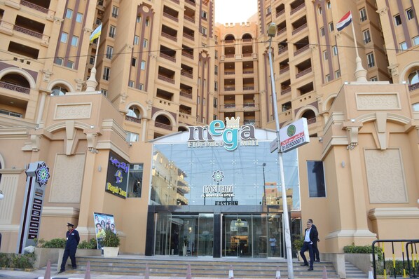 Entrada de un hotel con un cartel grande que dice "mega Florence Mall" y "Eastern Hotel".