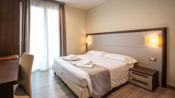Une chambre d’hôtel comprenant un lit, des tables de chevet, un bureau et une chaise.