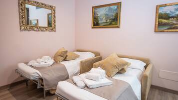 Une chambre d’hôtel avec deux lits, un grand miroir et deux tableaux encadrés accrochés au mur.