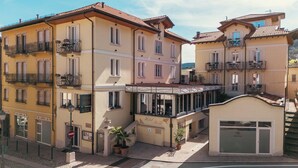 A multi-story hotel with balconies, a bar, and a restaurant. - Hotel Rosa (Baveno)