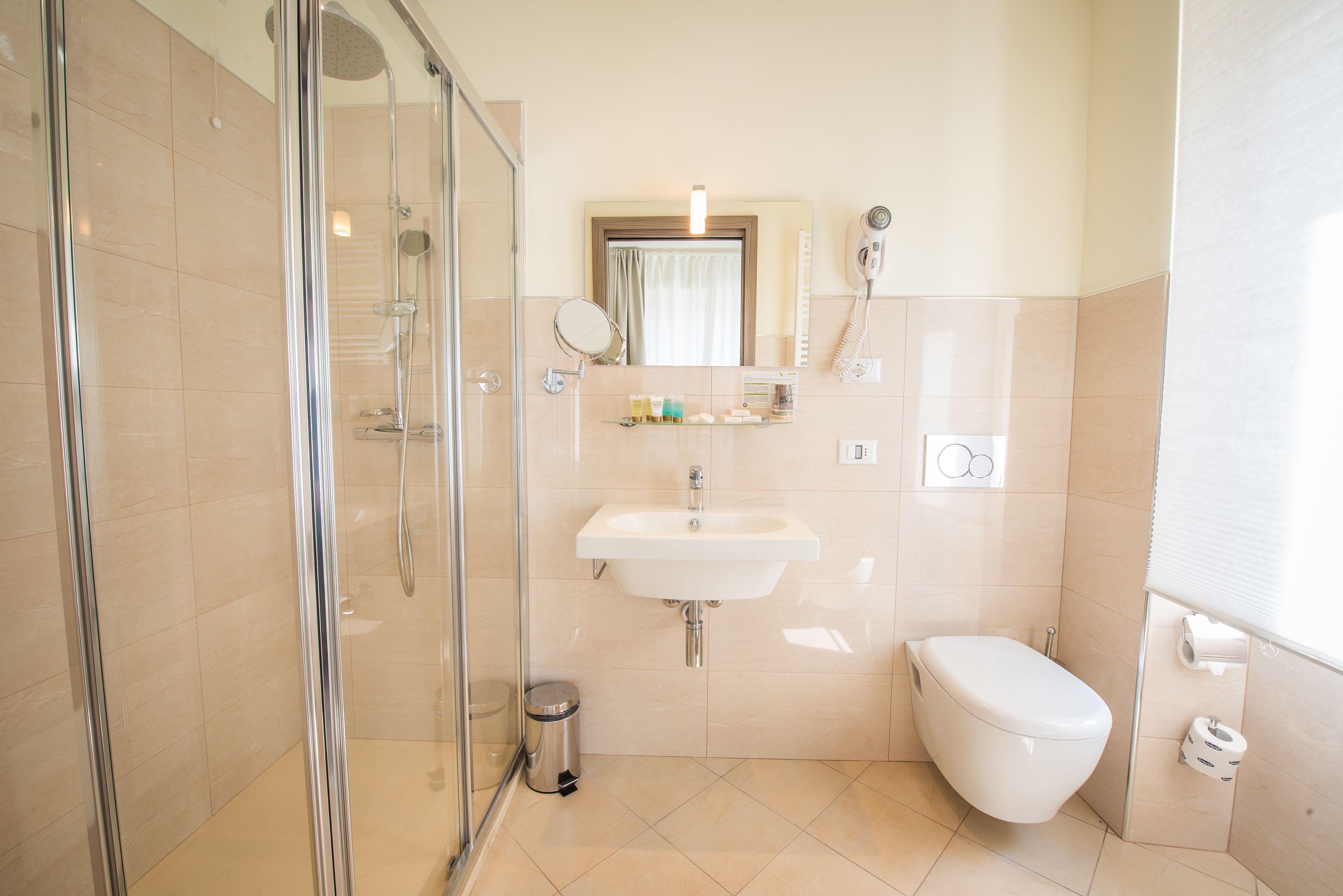 A modern bathroom with a glass-enclosed shower, a white sink, and a toilet.