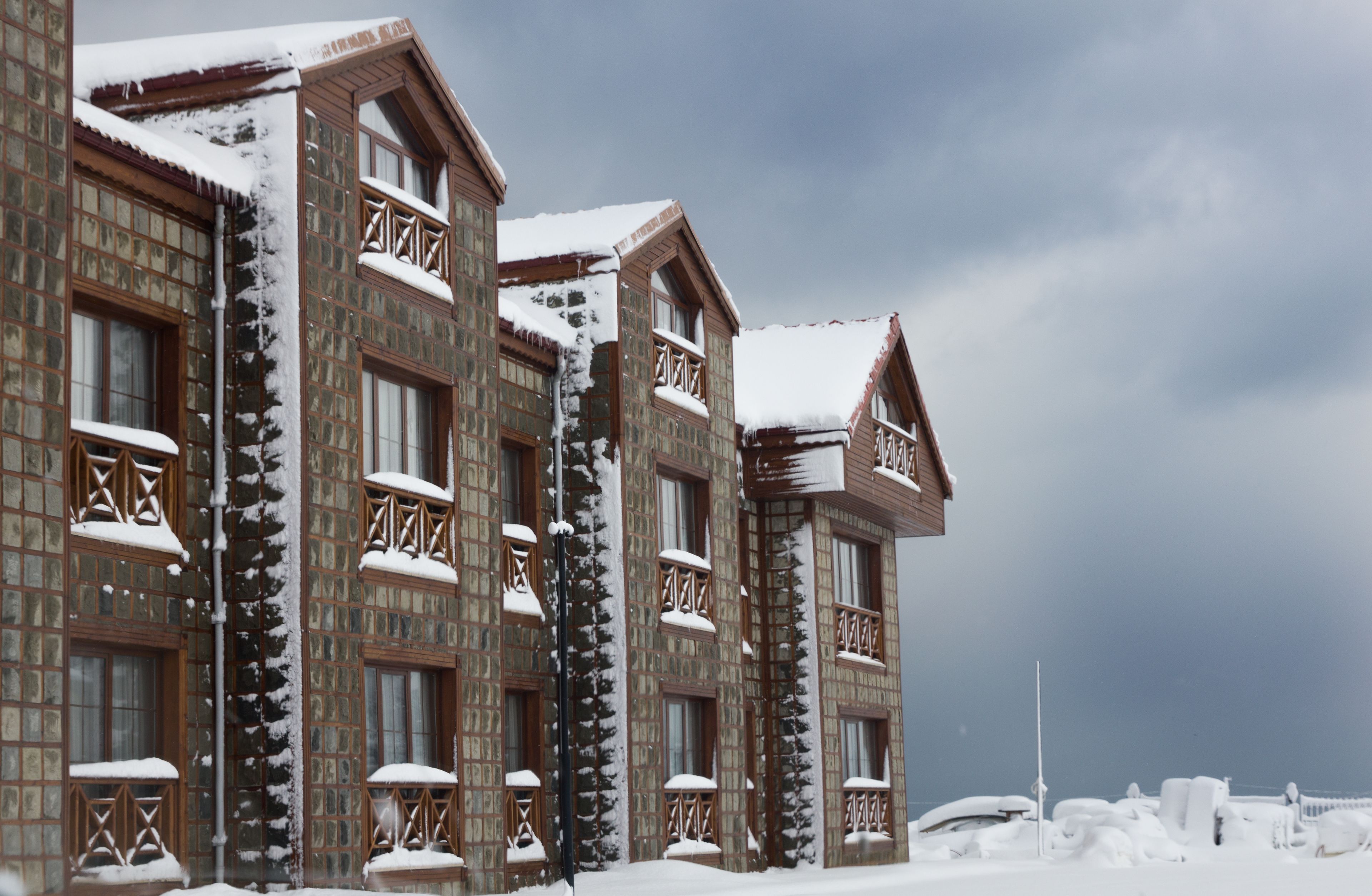 A large building with multiple windows and balconies, covered in snow.