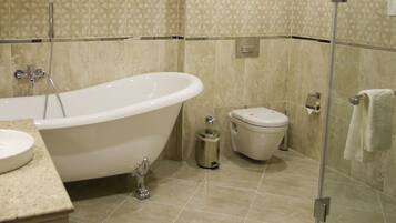 A bathroom with a freestanding bathtub, a toilet, and a sink.