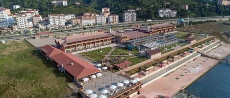 An aerial view of a hotel with multiple buildings, a swimming pool, and a parking area.