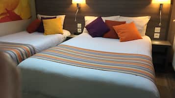Een hotelkamer met twee bedden, elk voorzien van gestreept beddengoed en meerdere kussens in verschillende kleuren. Er staan wandlampen voor verlichting, en een groot abstract schilderij aan de muur.