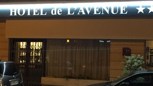 L'extérieur de l'HÔTEL de L'AVENUE, avec une enseigne bien visible au-dessus de l'entrée.